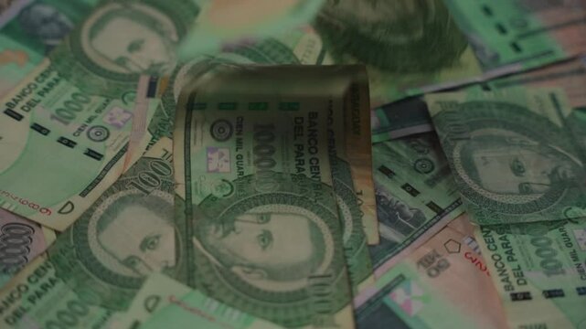 Close-up of guaran&iacute; bills falling