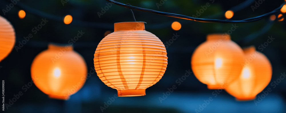 Poster a group of orange lanterns hanging from a string. the lanterns are lit up and create a warm and invi