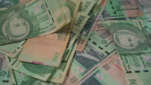 Close-up of guaran&iacute; bills falling
