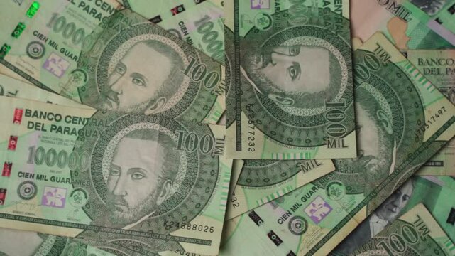 Close-up panoramic view of one-hundred-thousand guaran&iacute; bills from Paraguay