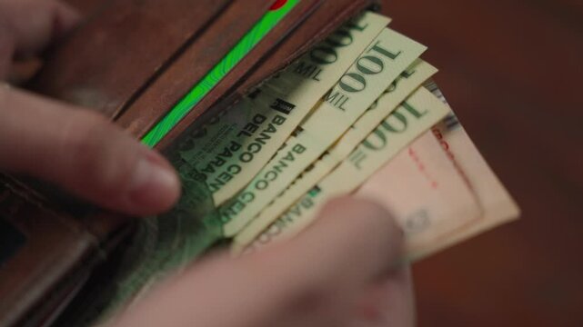 Wallet with Paraguayan guaran&iacute; bills, including one-hundred-thousand guaran&iacute;