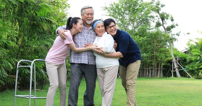 Portrait enjoy happy smiling love multi-generation asian big hug family.Senior mature father and elderly mother with young adult woman and son outdoor in park at home.insurance concept
