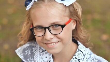 Portrait of a smiling 13 year old girl put on glasses. Face close up.