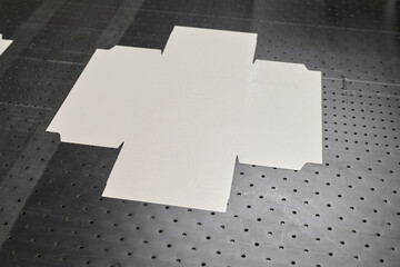 Cardboard packaging factory showcases efficient paper wrap cutouts on conveyor after glue...