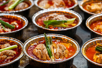 Cooked brains with chili pepper sauce in aluminium tubs Sichuan snacks