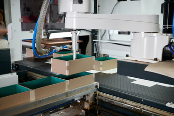 Innovative robot technology streamlines the gluing process of cardboard boxes in a modern manufacturing plant