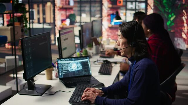 Call center agents track shipments in office using AI chatbot for help. Customer center workers use artificial intelligence assistance to locate clients packages and provide status updates, camera B