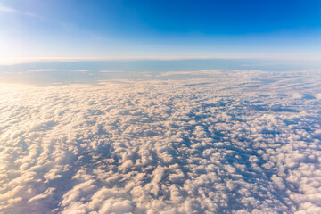 Beautiful orange and pink sunrise over the clouds, view from the plane.