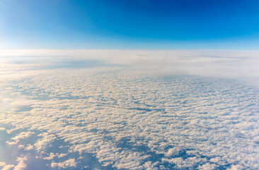 View from the airplane window at a beautiful cloudy sky and the airplane wing
