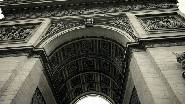 Exploring the intricate architecture of the Arc de Triomphe in Paris under cloudy skies
