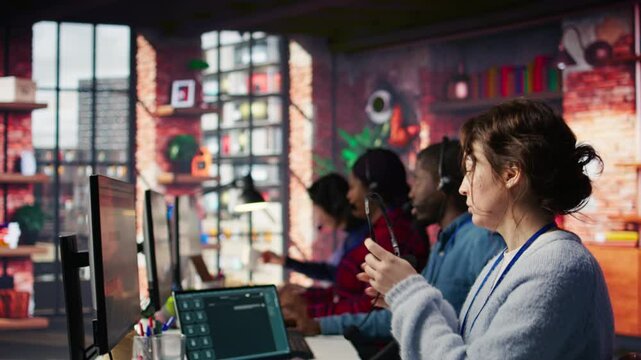 Call center employee starting job shift, sitting down at desk, handling complaints. Customer service agent arriving at work, listening to customer needs related to products or services, camera B