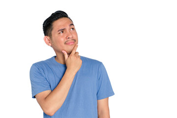 Smiling young Asian man touching chin while looking up with thoughtful expression, decision making,...