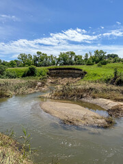 Creek bed with extended Root and soil layers on edge of pasture drop off 