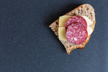 pieces of sausage and cheese are placed on a piece of bread   
