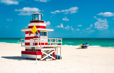 Fototapeta premium Beauty beach in Miami. Lifeguard tower on South Miami Beach. Miami Beach coastline. Famous Beach lifeguard. Travel to Miami. Art Deco lifeguard on Miamis shoreline.