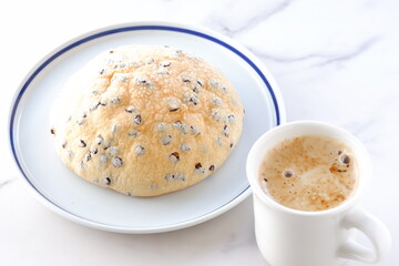 チョコチップ入りのメロンパンと、淹れたてのコーヒーで、ゆったりコーヒーブレイクを楽しむイメージ
