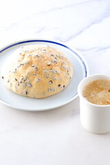 チョコチップ入りのメロンパンと、淹れたてのコーヒーで、ゆったりコーヒーブレイクを楽しむイメージ
