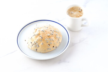 チョコチップ入りのメロンパンと、淹れたてのコーヒーで、ゆったりコーヒーブレイクを楽しむイメージ
