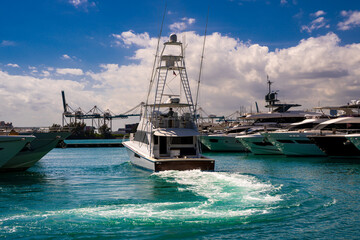 Naklejka premium Yacht sailing on sea waters. Luxury superyacht at sea. Miami Beach with yachts. Tropical seascape with a sailboat. Cruise ship near the coastline. Sunset yacht voyage in Florida. Yacht in ocean.