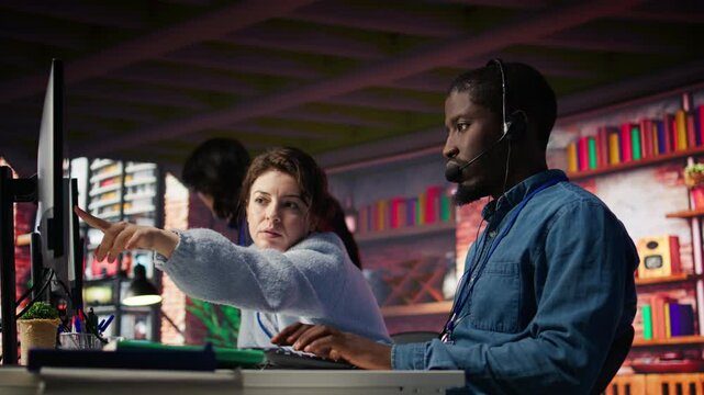 Call center manager supervising agent providing step by step guidance to customers. Customer center supervisor overseeing work done by employee walking clients through technical solutions, camera B