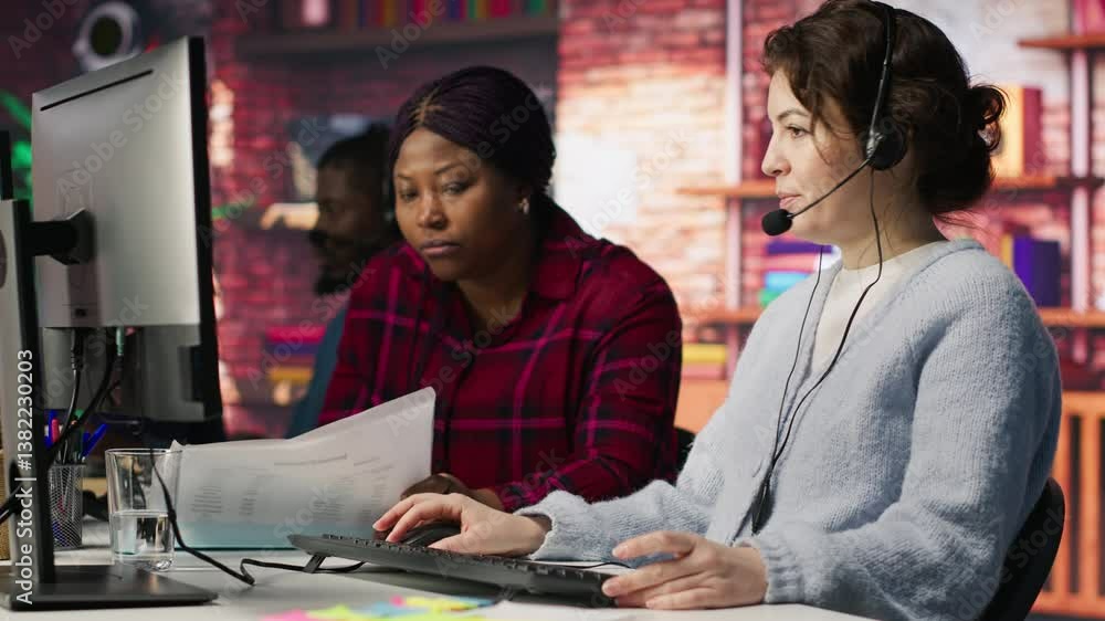 Poster call center team leader going over paperwork files next to colleague at pc desk. customer support ma