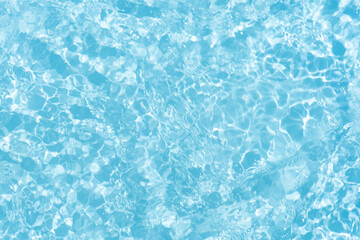 Blue water with ripples on the surface. Defocus blurred transparent blue colored clear calm water surface texture with splashes and bubbles. Water waves with shining pattern texture background.