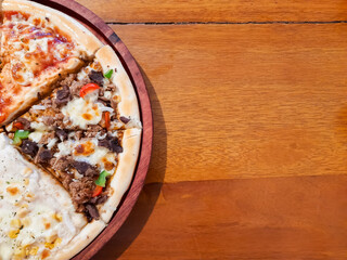 Assorted Pizza Slices on Wooden Table with Copy Space