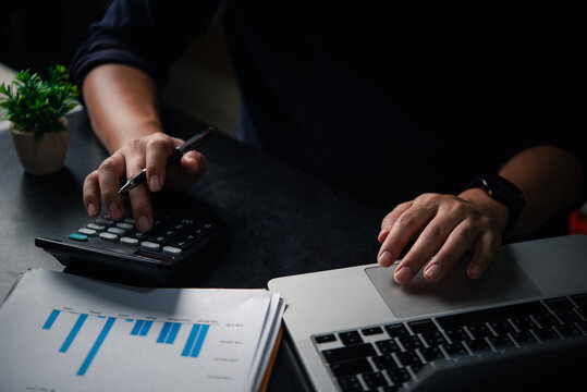 Accounting process with calculator, business chart and laptop, small business finance, planning strategy, and personal or professional financial management. Business bookkeeping payroll and tax.