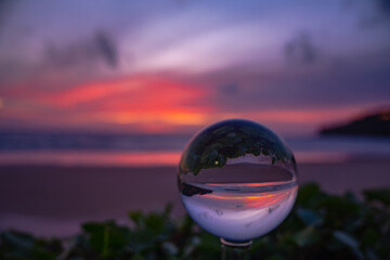 A captivating sunset reflected through a crystal ball, creating an inverted and artistic...