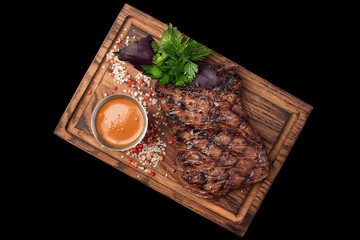 Large Grilled Steak with Sauce and Herbs, Top View, Wooden Plate, Black Background, Isolated for Restaurant Menu