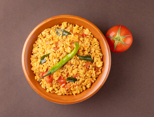 Indian Traditional Tomato rice with vegetables serve in bowl isolated on dark background 
