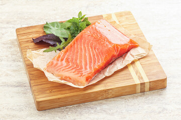Raw salmon fillet over board