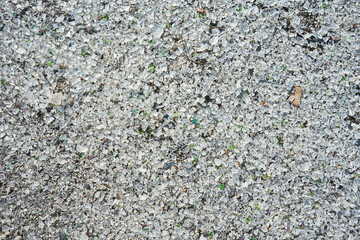 Many small pieces of broken shattered glass of different colors. Abstract texture gray background.  Abandoned destroyed Glass Factory area. 