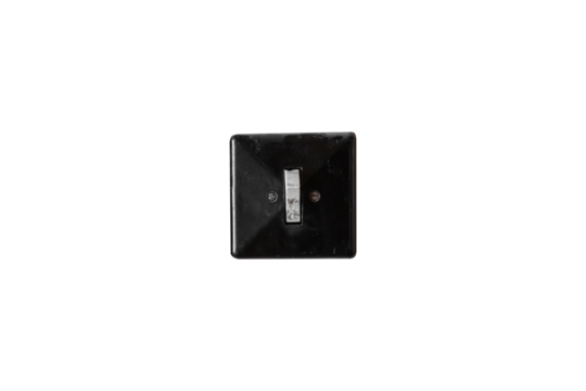 Old black plastic light switch is isolated. Vintage electrical toggle switch with visible wear.