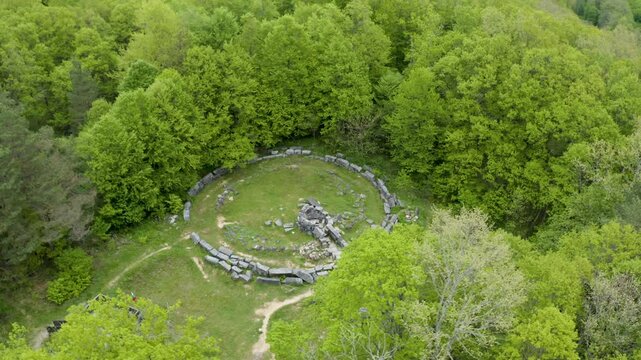 Circular drone shot above the ruins of Mishkova Niva tomb and its surrounding forest on Strandzha Mountain in the municipality of Malko Tarnovo in Bulgaria.