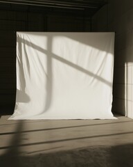 Minimalist white backdrop in sunlit warehouse with dramatic shadows