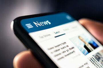 News and press. Media release. Newspaper reading with phone. Digital online article and headlines on website. Report, publication or blog. Mockup of daily mobile portal feed.