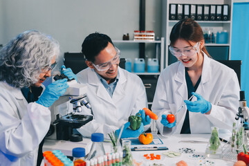 Team Asian scientists in a lab conducting food research using a microscope and lab equipment,...