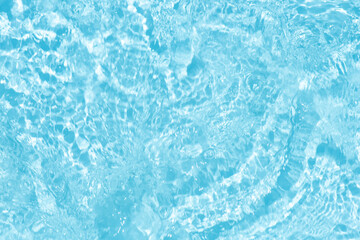 Blue water with ripples on the surface. Defocus blurred transparent blue colored clear calm water surface texture with splashes and bubbles. Water waves with shining pattern texture background.