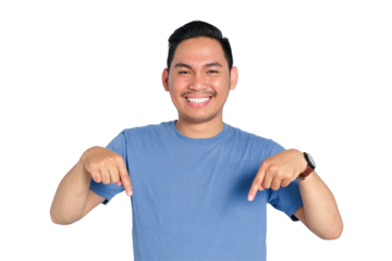 Happy young Asian man smiling and pointing downward with both hands, wearing casual blue t-shirt, isolated on transparent background