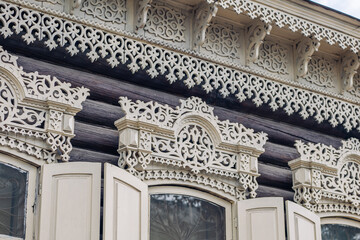 Fototapeta premium Intricate carvings embellish the window frames of a historic wooden house, showcasing the rich heritage of russian architecture