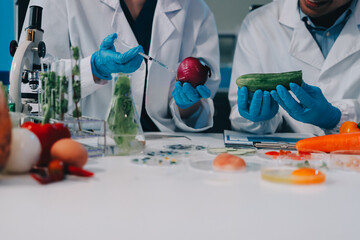 Team Asian scientists in a lab conducting food research using a microscope and lab equipment,...