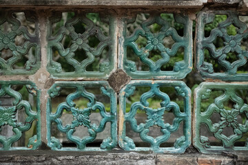 Section of green ceramic lattice tiles forming repeating decorative temple motif in Ninh Bình, Vietnam on December 26, 2019