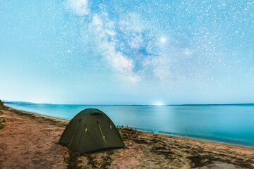 Milky Way over illuminated camping tent
