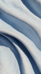 Faded blue denim texture with soft folds and realistic textile detail for modern phone wallpaper.

