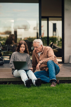 Grandfather and granddaughter discussing sustainable energy plans in the garden
