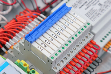 Intermediate ultra-thin relays on a metal di-rack in an electrical panel. 
