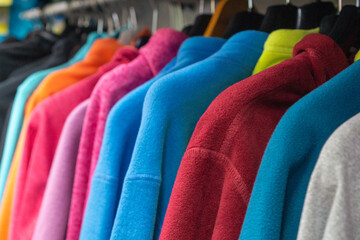 Many fleece clothes in store close-up, selective focus © Mikhail Taratonov