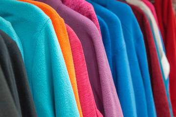 Many fleece clothes in store close-up, selective focus