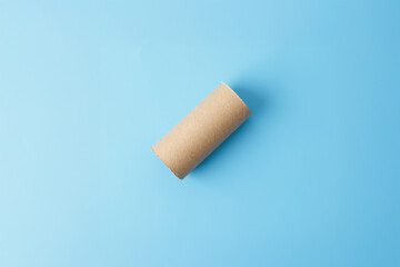 Minimalistic cardboard tube on blue background for eco-conscious designs, sustainable crafts, and...